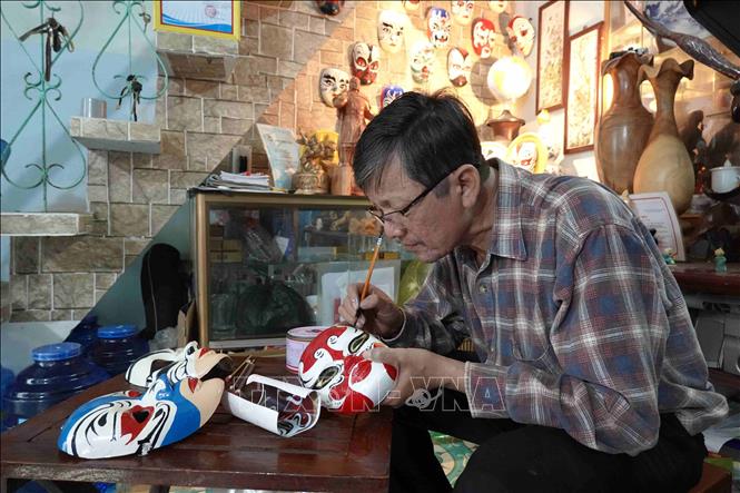 Trong ảnh: Để hoàn thành một sản phẩm mặt nạ chân dung nghệ thuật hát bội, ông Vân nhập tâm vào nhân vật vẽ trong 2 giờ. Ảnh: Tường Quân - TTXVN