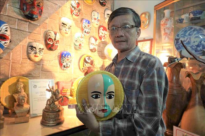 Photo: Mr. Tran Ngoc Van presents one of his masks. VNA Photo: Tường Quân