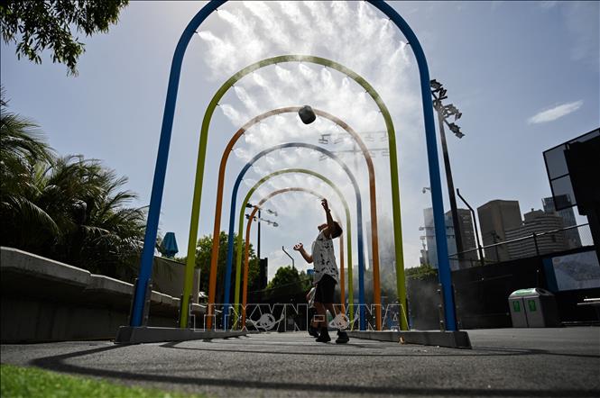 Trong ảnh (tư liệu): Trẻ em tránh nóng dưới vòi phun nước tại Melbourne, Australia. Ảnh: AFP/ TTXVN