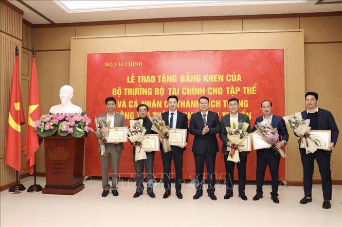 Thứ trưởng Bộ Tài chính Nguyễn Đức Chi trao tặng Bằng khen của Bộ trưởng cho các cá nhân có thành tích xuất sắc trong công tác thông tin, tuyên truyền. Ảnh: Minh Quyết - TTXVN