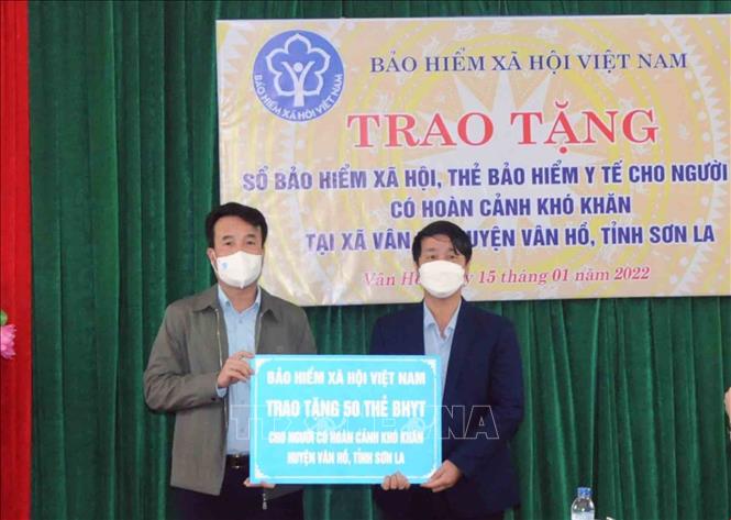 Trong ảnh: Tổng Giám đốc Bảo hiểm Xã hội Việt Nam Nguyễn Thế Mạnh (bên trái) trao tặng tượng trưng 50 thẻ Bảo hiểm Y tế cho người dân có hoàn cảnh khó khăn trên địa bàn huyện Vân Hồ, tỉnh Sơn La. Ảnh: Quang Quyết-TTXVN
