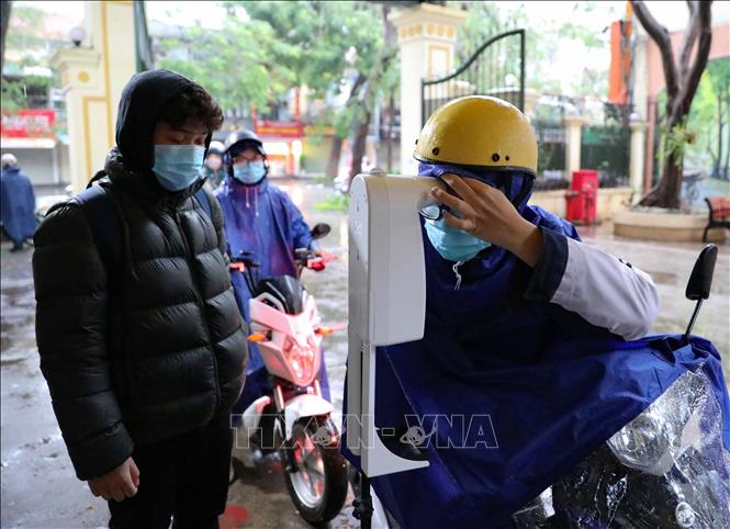 Trong ảnh: Học sinh lớp 12 trường THPT Việt Đức (quận Hoàn Kiếm) thực hiện đo thân nhiệt khi tới trường học trực tiếp từ sáng 17/1/2022. Ảnh: Thanh Tùng - TTXVN