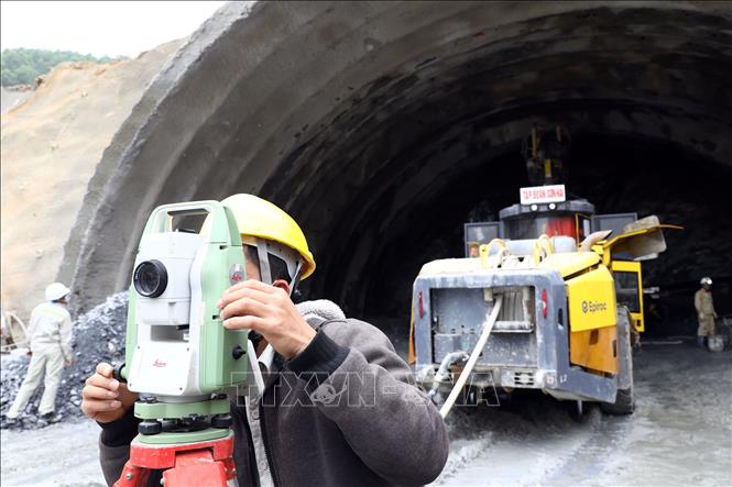Công nhân tiến hành đo đạc tọa độ thi công tại khu vực cửa hầm Trường Vinh. Ảnh: Huy Hùng - TTXVN