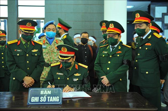 Trong ảnh: Lãnh đạo Bộ Quốc phòng viết cảm tưởng vào sổ tang tại Lễ viếng Liệt sĩ, Trung tá Đỗ Anh. Ảnh: Minh Đức – TTXVN