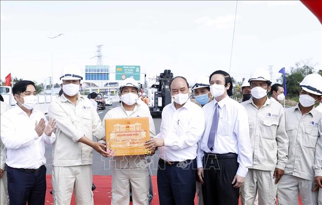 Chủ tịch nước Nguyễn Xuân Phúc tặng quà cho công nhân lao động Tập đoàn Đèo Cả (đơn vị thi công dự án). Ảnh: Thống Nhất - TTXVN
