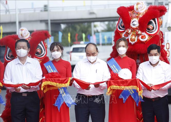 Chủ tịch nước Nguyễn Xuân Phúc cùng các đại biểu thực hiện nghi thức thông xe. Ảnh: Thống Nhất - TTXVN
