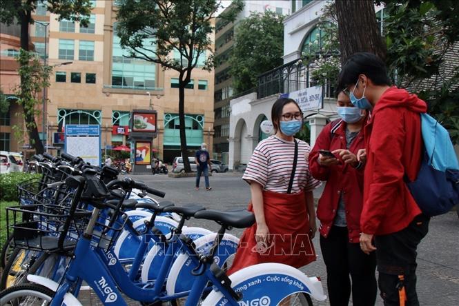 Photo: Young people download mobile app to use the bike rental service. VNA Photo: Tiến Lực