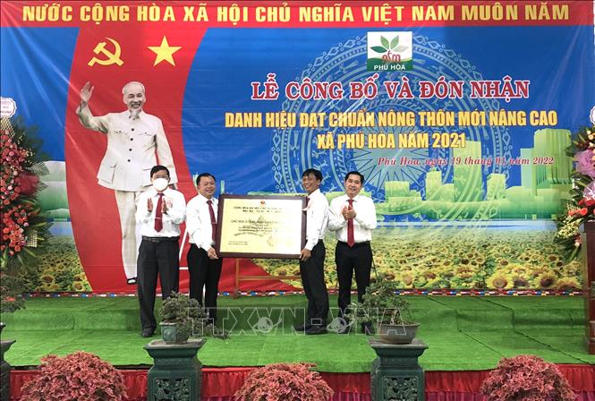 Đại diện lãnh đạo huyện Định Quán trao bằng công nhận xã Phú Hòa đạt chuẩn nông thôn mới nâng cao. Ảnh: Nguyễn Văn Việt - TTXVN
