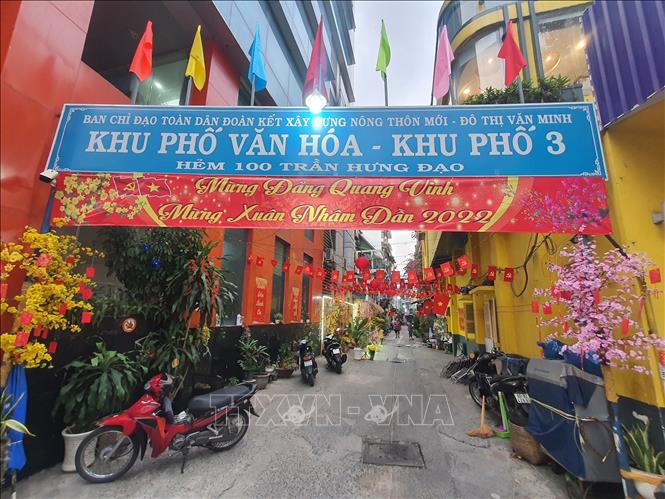 Trong ảnh: Khu phố 3, hẻm 100 đường Trần Hưng Đạo (Quận 1), nổi bật với nền tường màu vàng kèm các tiểu cảnh tranh trí Tết. Ảnh: Thu Hương - TTXVN