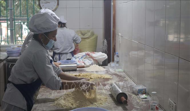 Trong ảnh: Công đoạn trộn bột với đường phên trong quy trình làm bánh khảo. Ảnh: Chu Hiệu-TTXVN