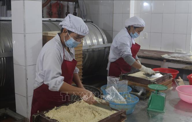 Trong ảnh: Bột sau khi được trộn với đường phên thì cho vào khuôn để nén thành bánh. Ảnh: Chu Hiệu-TTXVN