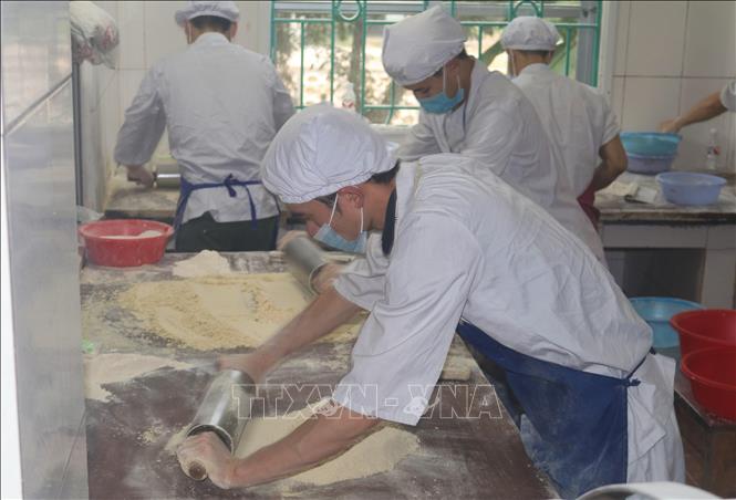 Trong ảnh: Công đoạn trộn bột với đường phên trong quy trình làm bánh khảo. Ảnh: Chu Hiệu-TTXVN