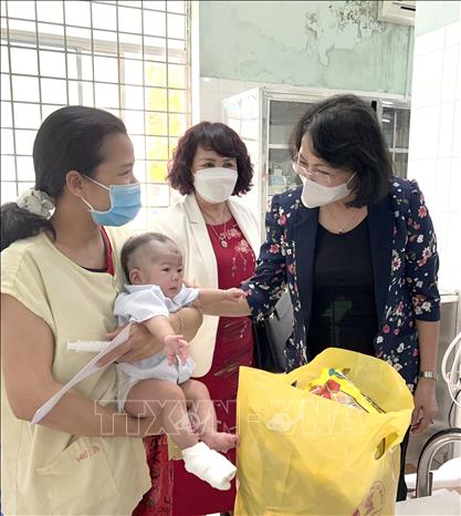 Trong ảnh: Nguyên Phó Chủ tịch nước Đặng Thị Ngọc Thịnh hỏi thăm và tặng quà Tết cho gia đình bệnh nhi đang điều trị tại Bệnh viện Đa khoa Bình Định. Ảnh: Nguyên Linh-TTXVN 