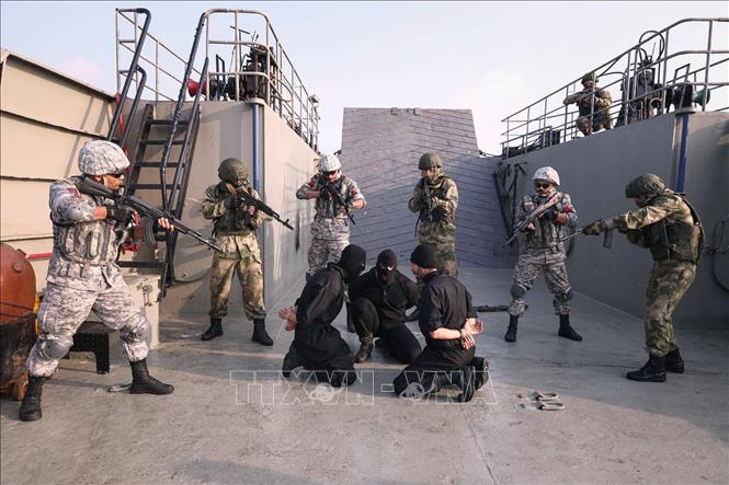 Trong ảnh: Binh sĩ Iran, Nga và Trung Quốc tham gia  cuộc tập trận trên không và trên biển ở Ấn Độ Dương nhằm chống cướp biển ngày 21/1/2022. Ảnh: AFP/TTXVN