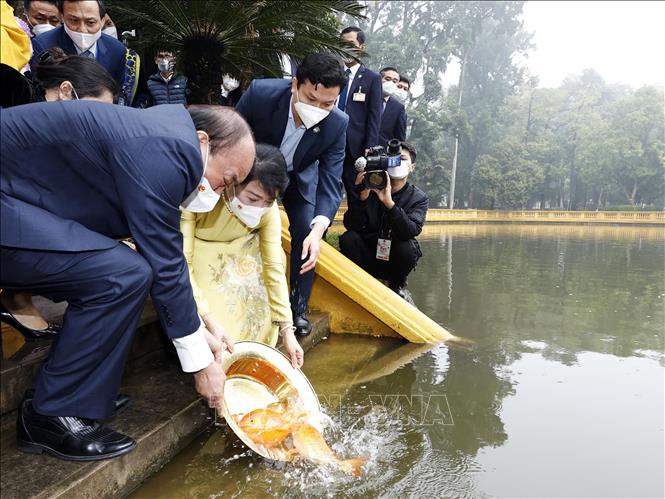 Chủ tịch nước Nguyễn Xuân Phúc và Phu nhân thả cá tại Ao cá Bác Hồ, trong Khu di tích Phủ Chủ tịch. Ảnh: Thống Nhất – TTXVN