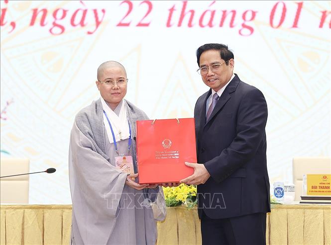 Trong ảnh: Thủ tướng Phạm Minh Chính tặng quà lưu niệm cho các kiều bào dự Xuân quê hương năm 2022. Ảnh: Dương Giang-TTXVN
