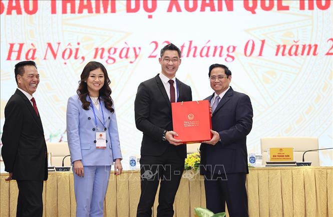 Trong ảnh: Thủ tướng Phạm Minh Chính tặng quà lưu niệm cho các kiều bào dự Xuân quê hương năm 2022. Ảnh: Dương Giang-TTXVN
