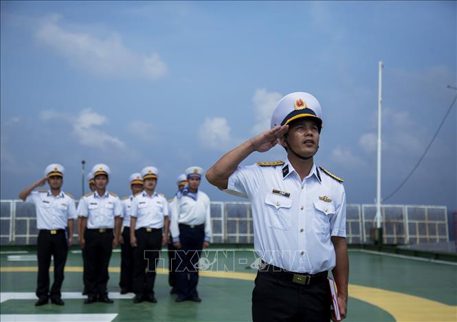 Trong ảnh: Thiếu tá Lê Văn Sỹ, Chỉ huy trưởng Nhà giàn DK1/9 điều hành Lễ chào cờ. Ảnh: Hồng Đạt - TTXVN
