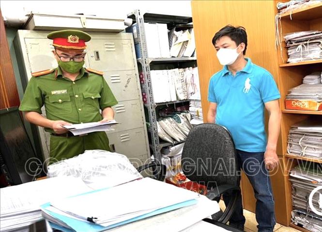 Trong ảnh: Lực lượng chức năng công bố lệnh bắt Vũ Văn Huy, công chức địa chính phường Tam Phước. Ảnh: TTXVN phát
 