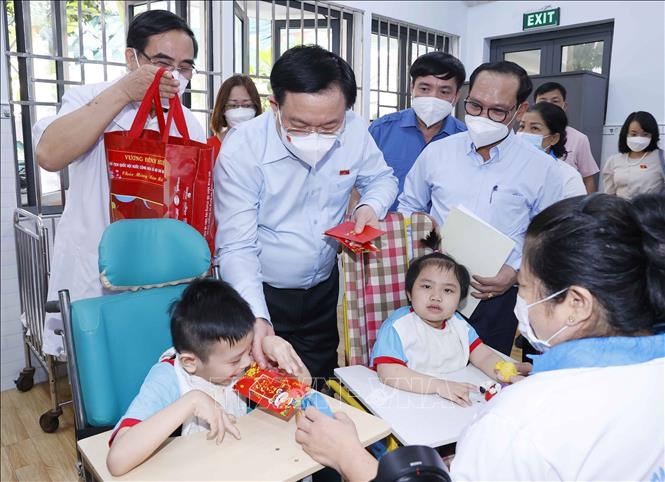 Photo: NA Chairman Vuong Dinh Hue presents gifts to children at the city Centre for Rehabilitation and Support for Children with Disabilities. VNA Photo: Doãn Tấn 
