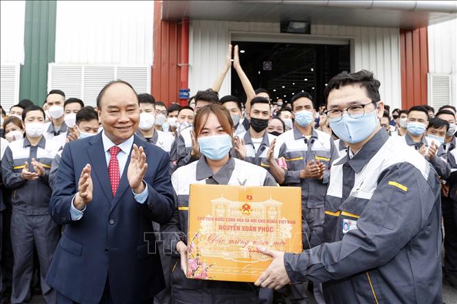 Chủ tịch nước Nguyễn Xuân Phúc tặng quà Tết công nhân lao động Công ty cổ phần sản xuất và kinh doanh Vinfast. Ảnh: Thống Nhất- TTXVN
