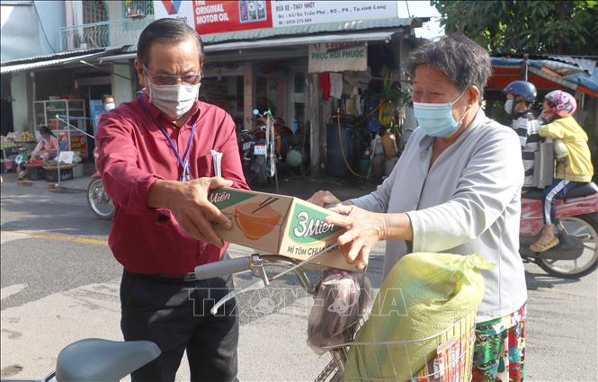 Ông Võ Thanh Vân - Phó Ban bảo trợ Hội Chữ thập đỏ thành phố Vĩnh Long, tỉnh Vĩnh Long trao quà Tết cho người nghèo. Ảnh: Lê Thúy Hằng - TTXVN