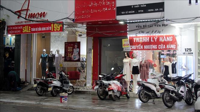Các shop thời trang tại đường Lê Hoàn, thành phố Thanh Hóa treo biển xả hàng nhưng vẫn ít khách mua.
Ảnh: Nguyễn Nam-TTXVN