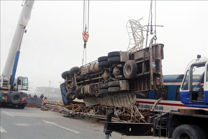Trong ảnh: Các lực lượng chức năng tiến hành tháo giỡ toa tàu để giải phóng đường ray. Ảnh: Đại Nghĩa - TTXVN