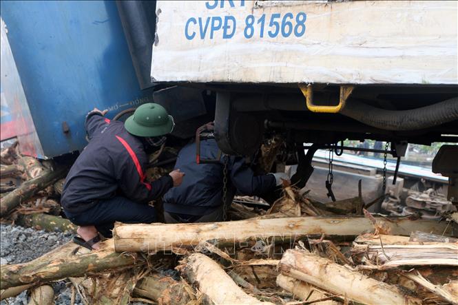 Trong ảnh: Các lực lượng chức năng đang tiến hành tháo giỡ toa tàu để giải phóng đường ray. Ảnh: Đại Nghĩa - TTXVN