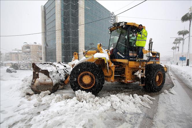 Trong ảnh: Công nhân dọn tuyết trên đường phố tại Amman, Jordan, ngày 27/1/2022. Ảnh: AFP/TTXVN