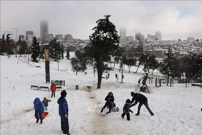 Trong ảnh: Người dân chơi đùa với tuyết tại Jerusalem, ngày 27/1/2022. Ảnh: AFP/TTXVN