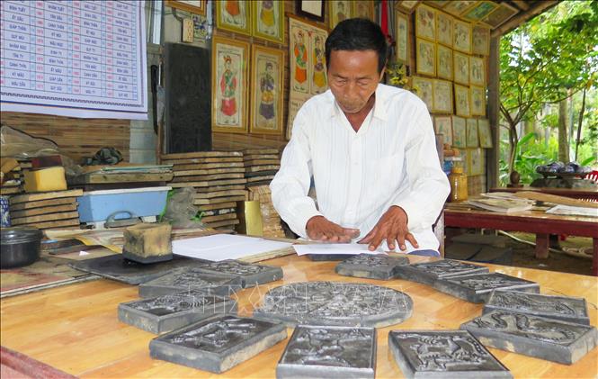 Trong ảnh: Nghệ nhân Kỳ Hữu Phước in tranh. Ảnh: Tường Vi - TTXVN