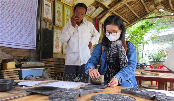 Trong ảnh: Nhiều người dân và du khách về làng Sình để trải nghiệm các công đoạn làm tranh dân gian truyền thống. Ảnh: Tường Vi - TTXVN