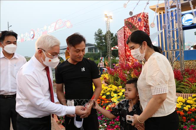 Bí thư Tỉnh ủy Bình Dương Nguyễn Văn Lợi thăm hỏi, tặng bao lì xì cho một gia đình xa quê ở lại ăn Tết . Ảnh: Chí Tưởng - TTXVN