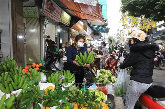Người mua chọn những nải chuối đẹp để thành kính dâng lên bàn thờ tổ tiên, sáng 31/1/2022 (29 tháng Chạp âm lịch). Ảnh: Hoàng Hiếu - TTXVN 