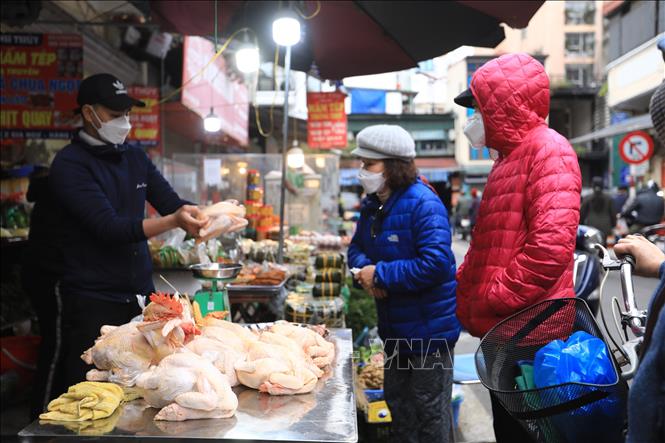 Nhiều người chọn mua gà đã làm sẵn, buộc đẹp để về chuẩn bị cho mâm cỗ cúng. Ảnh: Hoàng Hiếu - TTXVN 