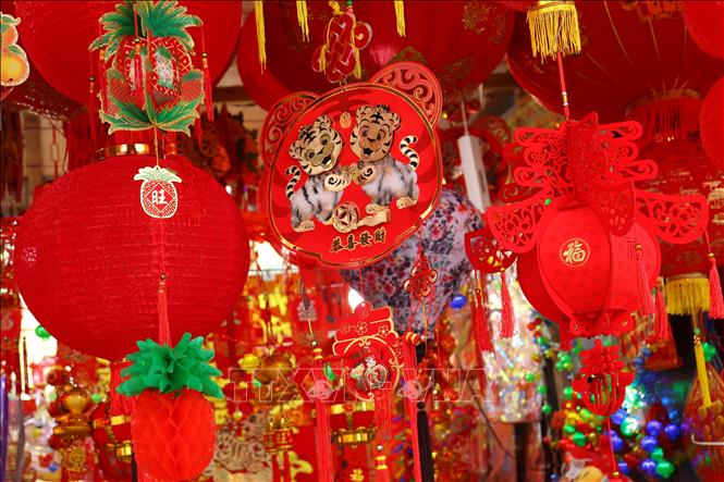 Trong ảnh: Đèn lồng, câu đối, dây kim tuyến, thẻ bài, tranh ảnh, đồ thờ cúng… được tìm mua nhiều nhất để trang hoàng nhà cửa. Những thứ khác không thể thiếu gồm phong bao, bao lì xì đỏ để mừng tuổi cho các em nhỏ và người già; hay bánh, mứt, kẹo… để đãi khách đến chơi nhà trong những ngày tết. Ảnh: Hữu Chiến - P/v TTXVN tại Jakarta