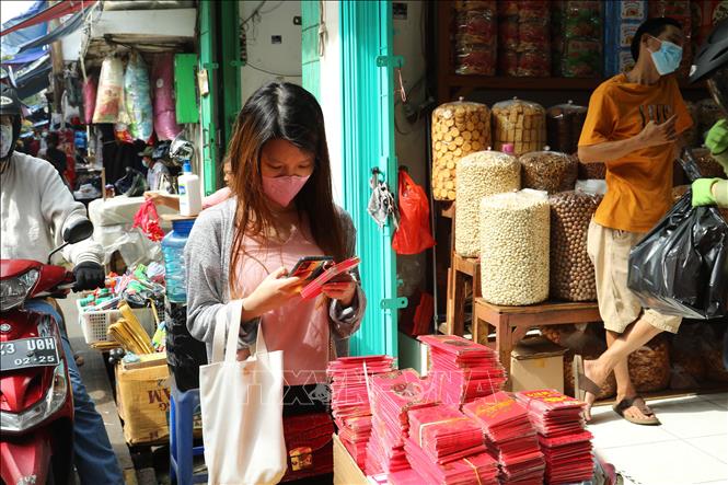 Trong ảnh: Khác hàng chọn mua bao lì xì mừng tuổi cho người già và trẻ em trong dịp Tết Nguyên đán. Ảnh: Hữu Chiến - P/v TTXVN tại Jakarta