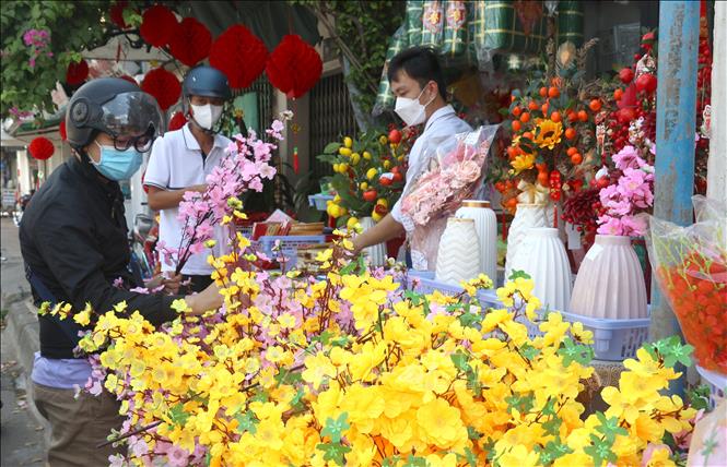 Trong ảnh :Người dân mua hoa về trang hoàng trong ngày Tết. Ảnh: Lê Thúy Hằng - TTXVN