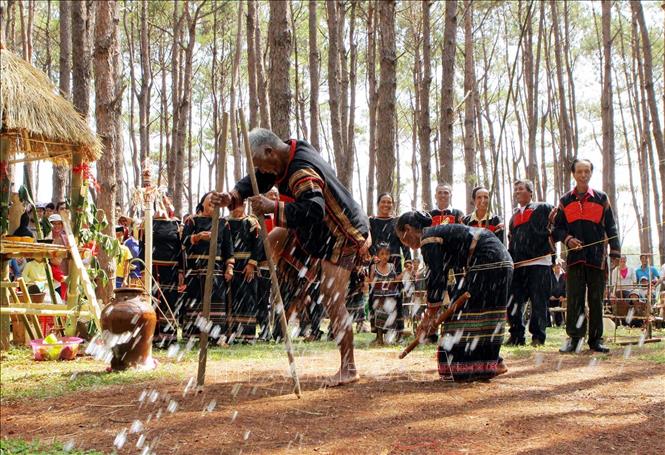 Photo: Ede people spray water over the ground to mimic rainfall as part of the rituals. VNA Photo: Dương Giang