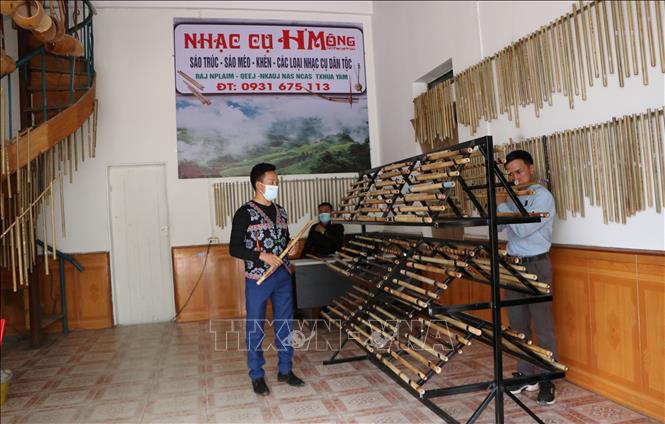 Hằng ngày có nhiều khách hàng đến xem sản phẩm và tập thổi sáo tại cửa hàng sáo trúc của 3 thanh niên người Mông. Ảnh: Việt Hoàng - TTXVN