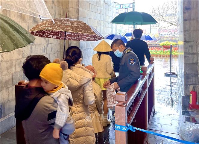 Du khách “đội mưa” đến tham quan Đại Nội Huế dịp đầu năm mới Nhâm Dần 2022. Ảnh: Mai Trang/TTXVN