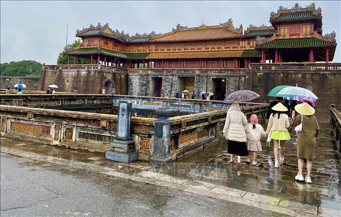 Du khách tham quan Đại Nội Huế dù thời tiết mưa lạnh. Ảnh: Mai Trang/TTXVN