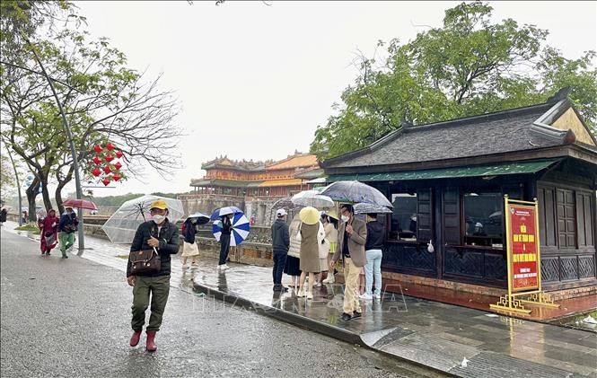 Điểm bán vé tham quan Đại Nội Huế vẫn đông khách dù trời mưa lạnh. Ảnh: Mai Trang/TTXVN