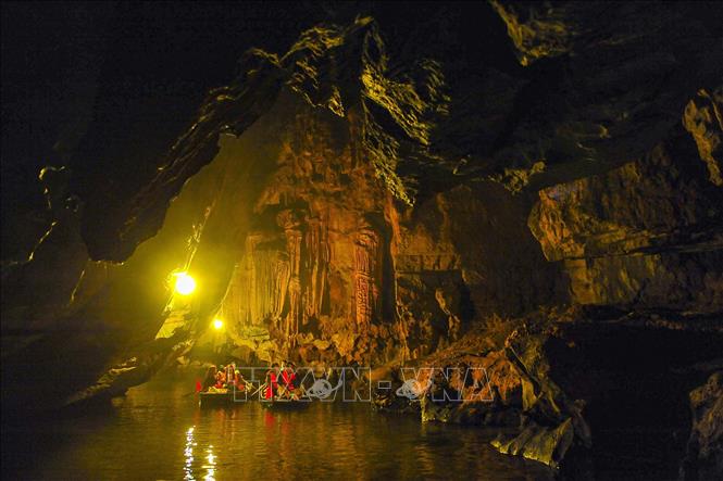 Trong ảnh: Du khách khám phá hang động trong Quần thể danh thắng Tràng An. Ảnh: Minh Đức - TTXVN

