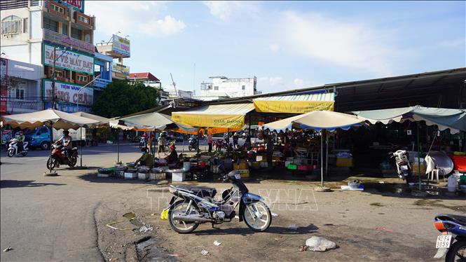Trong ảnh: Các tiểu thương cơi nới, che dù lấn chiếm lòng đường xung quanh Trung tâm thương mại Long Hoa. Ảnh: Thanh Tân - TTXVN