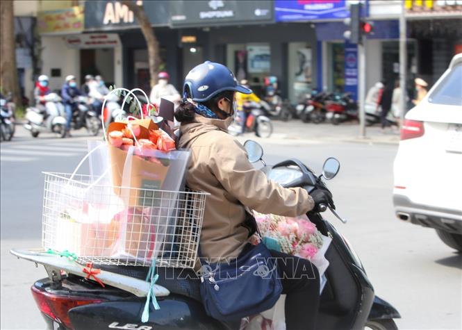 Nhiều người sử dụng dịch vụ vận chuyển hoa, quà khi không tiện đến mua trực tiếp. Ảnh: Tuấn Đức - TTXVN