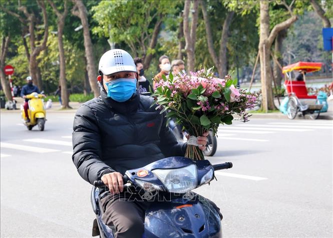 Hình ảnh bó hoa trên tay khá quen thuộc vào dịp Lễ Tình nhân. Ảnh: Tuấn Đức - TTXVN