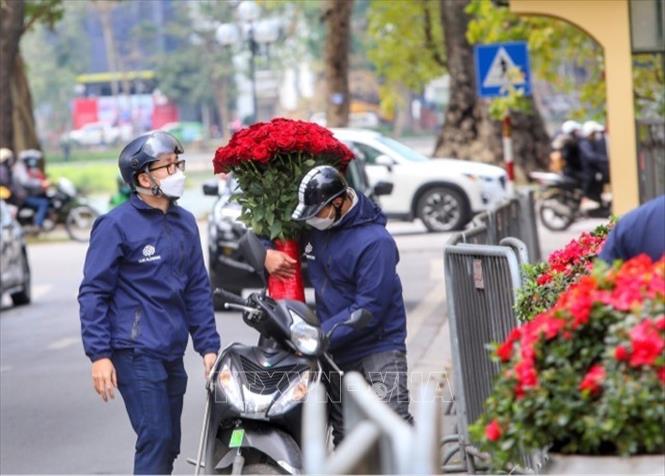Nhiều người sử dụng dịch vụ vận chuyển hoa, quà khi không tiện đến mua trực tiếp. Ảnh: Tuấn Đức - TTXVN