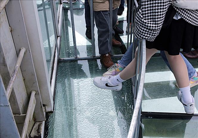 Trong ảnh: Khu vực miếng kính được cho là chủ đầu tư cố tình làm nứt, vỡ đã được khoanh vùng bảo vệ và luôn có nhân viên túc trực để giới thiệu, nhiều du khách vẫn muốn đặt chân để trải nghiệm. Ảnh: Quý Trung – TTXVN